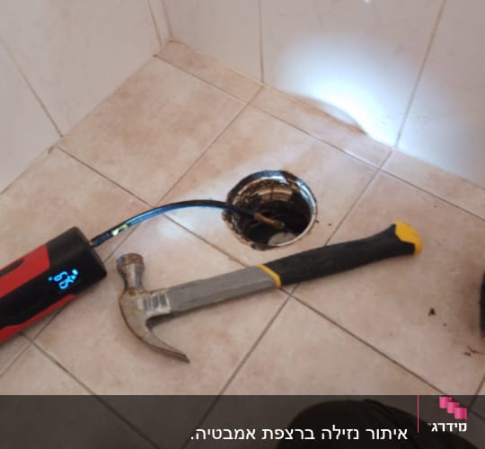 כלי עבודה וצינור ליד חור ברצפה